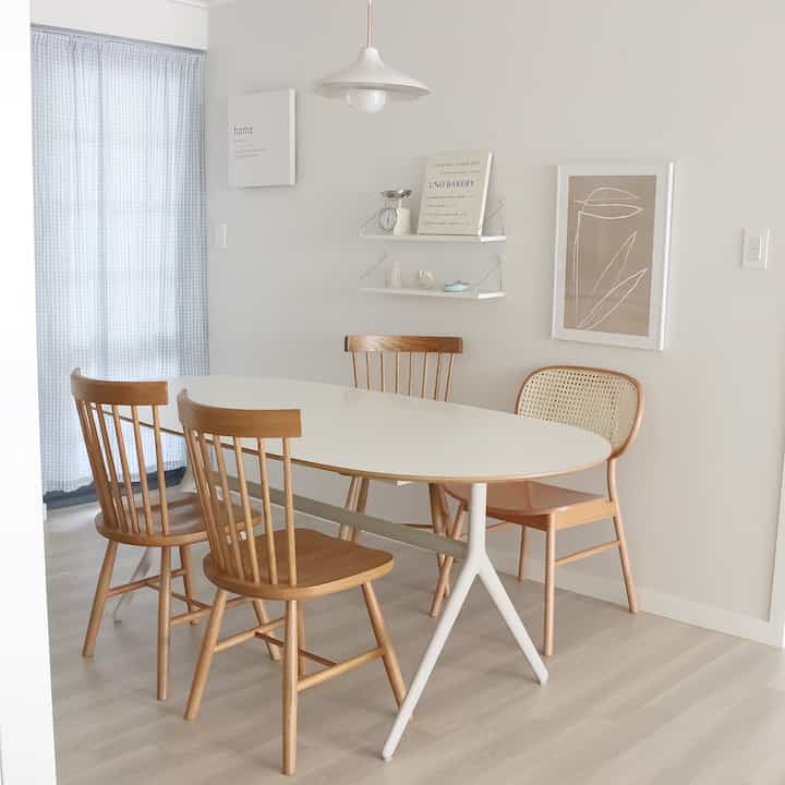 White and brown toned kitchen space featuring a dining table and chairs arranged neatly with a cozy atmosphere
