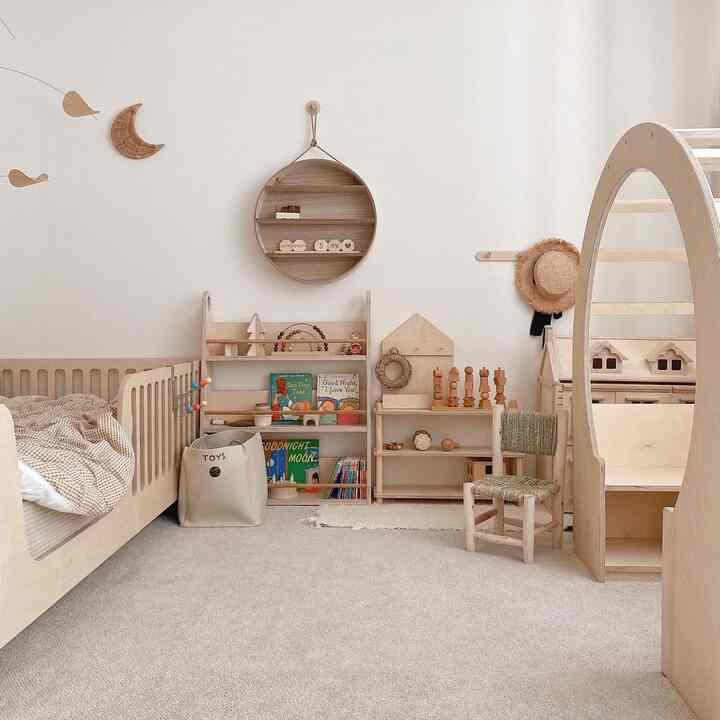 ベージュと木目調の色合いが調和した子供部屋、ベビーベッドとおもちゃ棚が配置された自然な雰囲気のあるインテリア