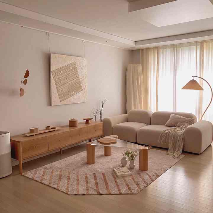 A soft white and natural brown toned living room featuring beige sofa and wooden furniture, creating a natural modern interior space