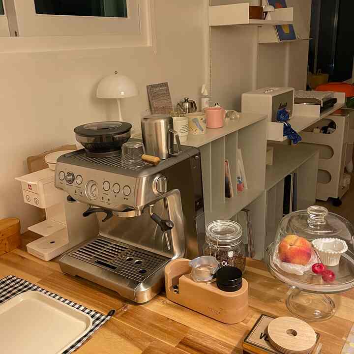 Wood tone kitchen space with white walls featuring a Breville coffee machine and coffee accessories, creating a tidy home cafe atmosphere