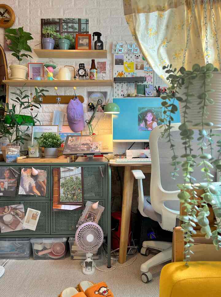 Small home office with white and wood tones, featuring desk, chair, and plants arranged for a cozy atmosphere