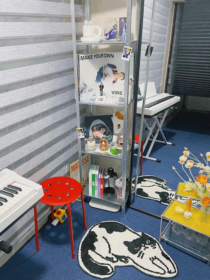 Blue and black toned home music space featuring red stool and metal shelf with a modern atmosphere