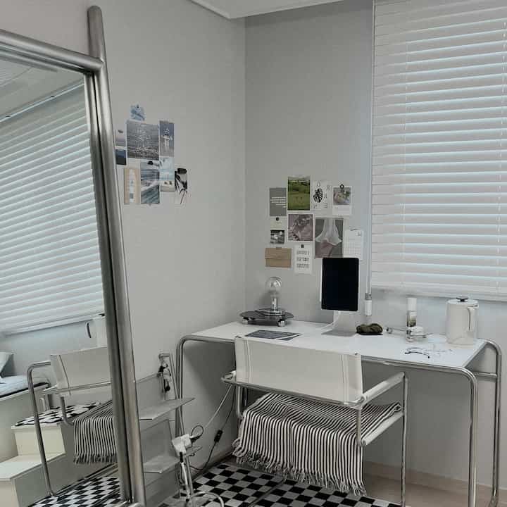 White-toned Mid-Century Modern compact home office featuring desk, chair, and blinds in a neat workspace