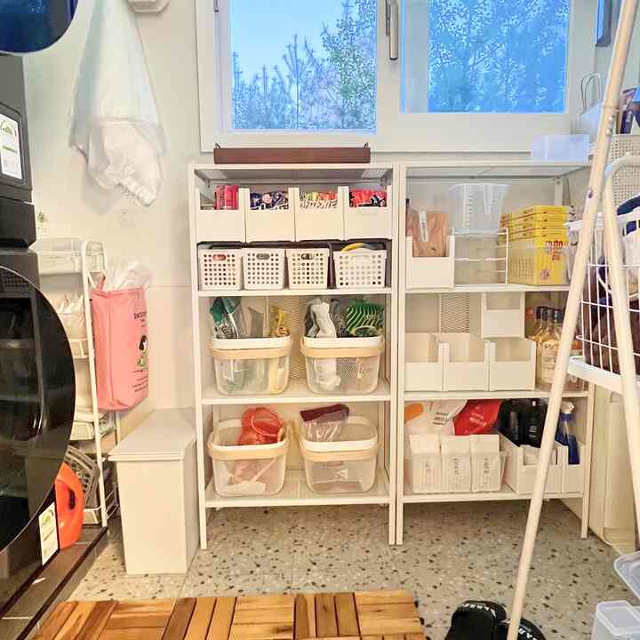 White shelves and wood tone flooring create a tidy veranda pantry space with organized storage and minimalist style