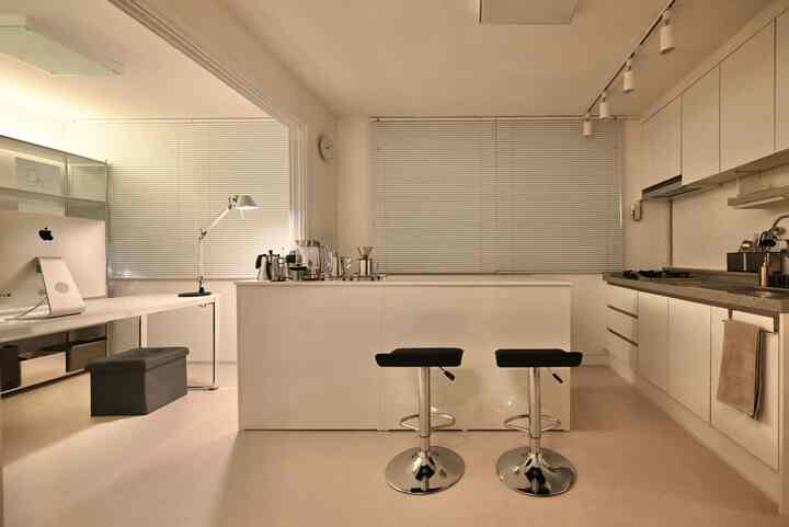 White and gray toned kitchen and home office space featuring minimalistic furniture and a clean, functional atmosphere