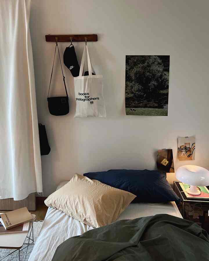 Modern natural bedroom in navy, beige, and green tones featuring bed, bedding, and wall art with calm atmosphere