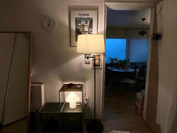 Natural white and brown toned living room featuring floor lamp and side table with a cozy atmosphere