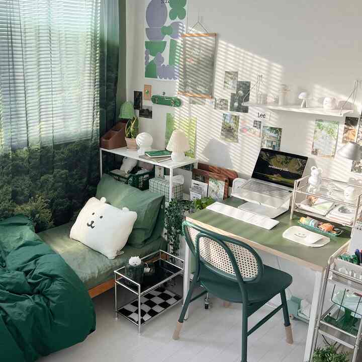 緑色のトーンが特徴的なワンルームのホームオフィス、デイベッドとデスク、椅子が配置された自然でくつろげるインテリア
