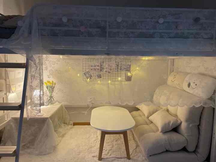 White and yellow toned small studio bedroom featuring cotton ball lights and cozy sofa bed with warm atmosphere