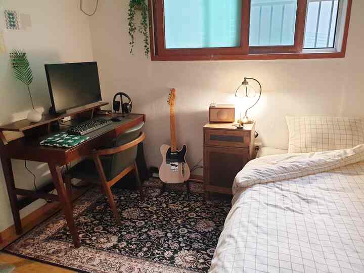 Natural wood tones and classic style in a 6-tatami bedroom featuring a computer workspace, musical instrument, and table lamp in a simple room