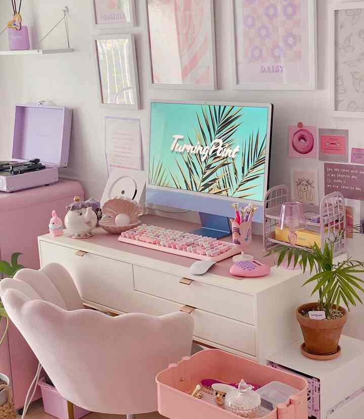 Pink and white toned home office featuring a desk with Apple iMac and pink accessories in a cozy setting