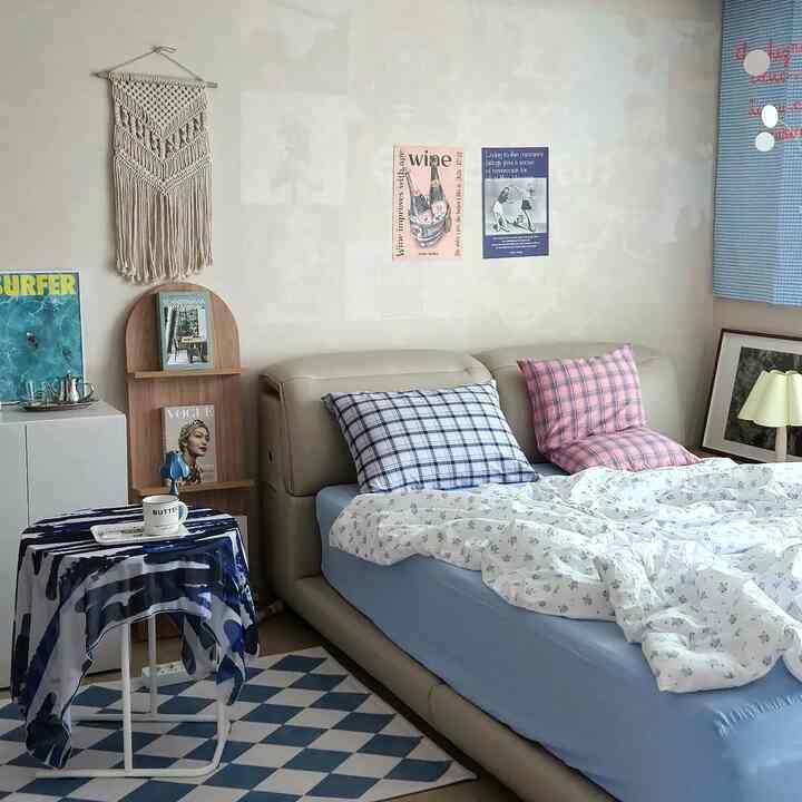 Ivory and blue toned bedroom featuring checkered cushions and posters with a natural modern style