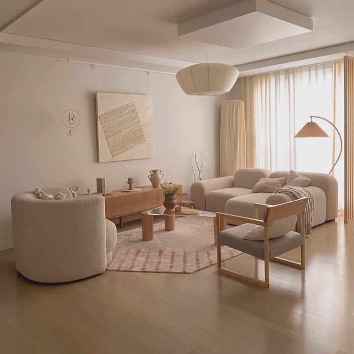 Natural color and wood tone living room featuring sofa and armchairs creating a warm, cozy atmosphere