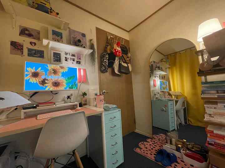 Small home office space in white and brown tones featuring a large arched mirror, desk, and drawer cabinet creating a cozy work area