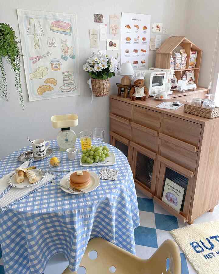 ブルーとベージュのトーンのワンルームおうちカフェ、チェック柄のテーブルクロスとバター色のチェアが配置された自然な雰囲気のインテリア