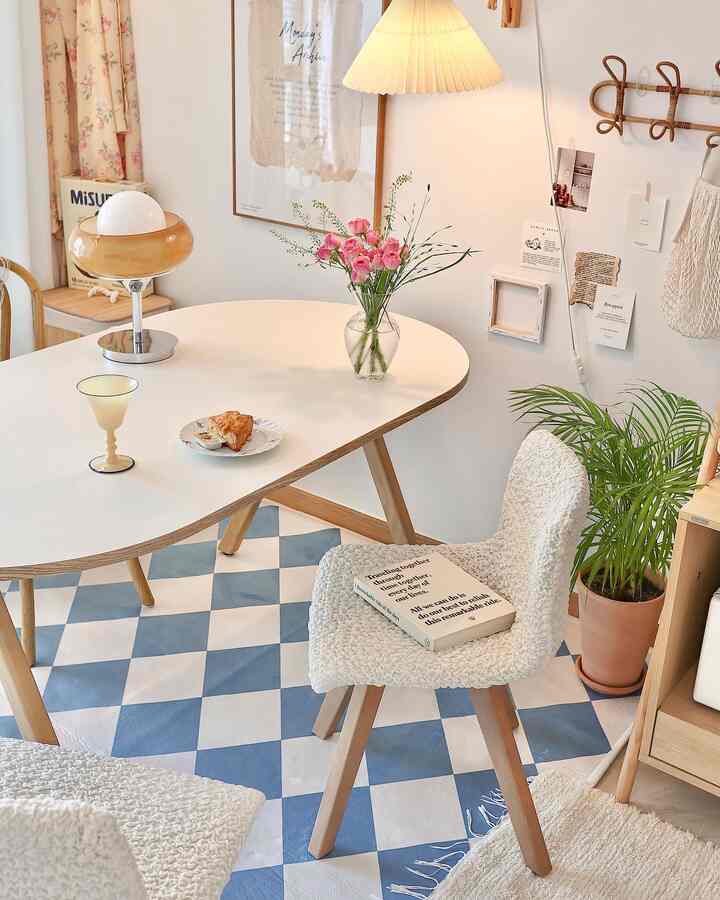 ホワイトとブルーのトーンのダイニング、ナチュラルモダンな雰囲気の木製テーブル、テクスチャの椅子、花瓶と植物が配置された空間