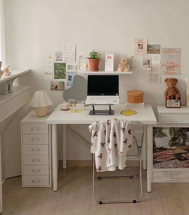 ホワイトとナチュラルウッドトーンのシンプルなホームオフィス、整理されたデスクと棚、ノートパソコンスタンドが配置された雰囲気のある作業空間