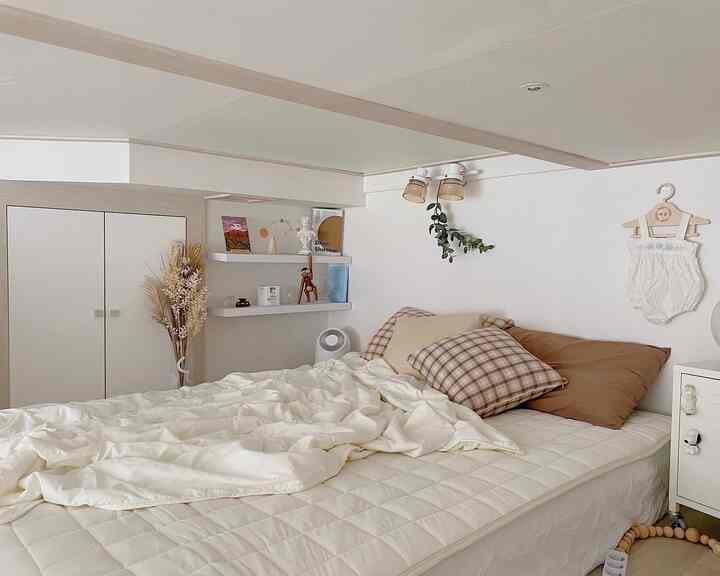 Natural-toned bedroom featuring beige and white bedding with wooden objet accents, creating a cozy atmosphere