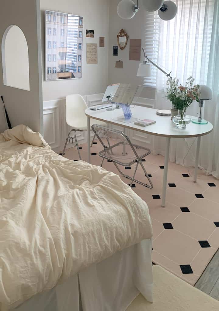 Ivory and white toned bedroom featuring transparent chairs and a round table in a clean, simple home office setup