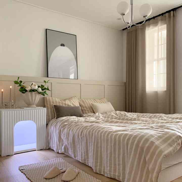 ベージュとホワイトの調和が美しい寝室、枕とベッドカバーが落ち着いた雰囲気を演出する