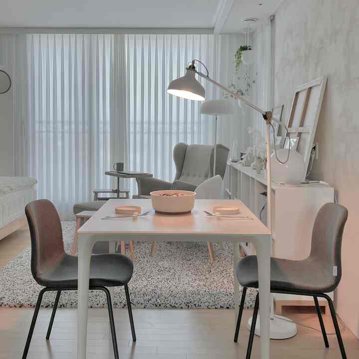Natural color minimal living and dining room with white curtains and dining table creating a cozy space