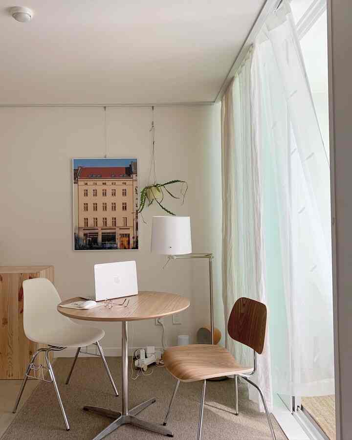 White and wood-tone bedroom home cafe featuring round table and chairs, creating a calm and simple atmosphere