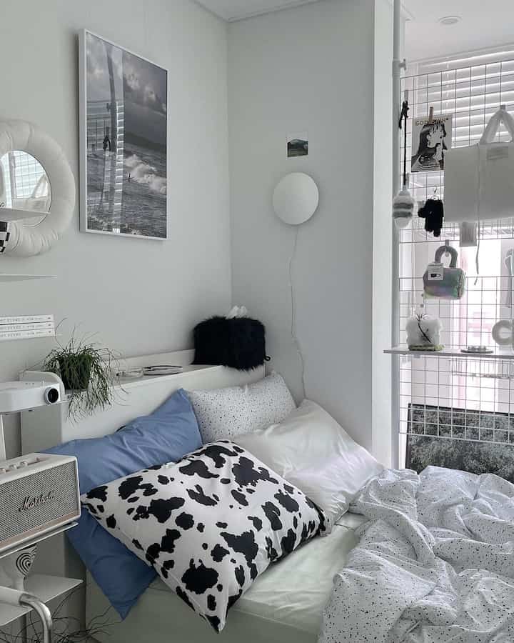 White and blue toned single bedroom featuring a neat bed and minimal modern decor