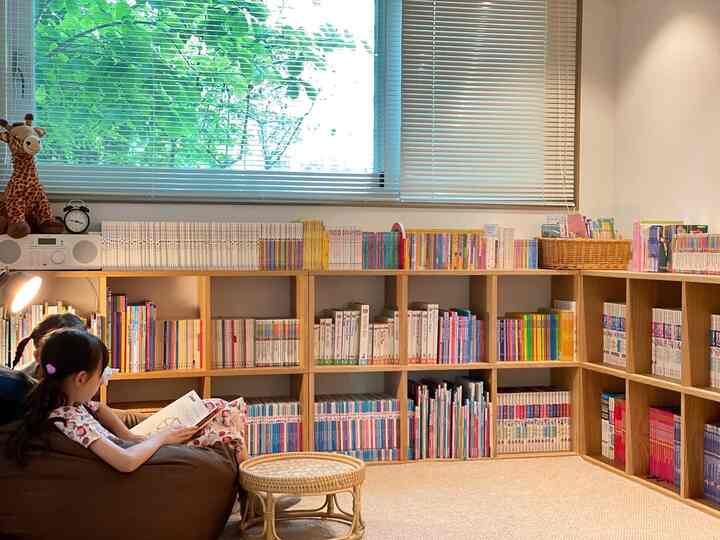 ナチュラルな色調の子供部屋、ビーズクッションのソファと本棚、ブラインドが配置された温かみのある居心地の良い空間