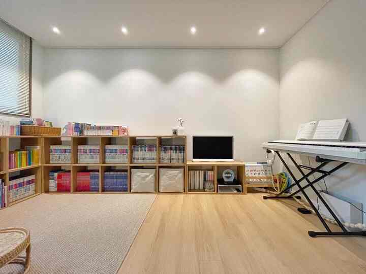 White walls and wood-tone floor with bookshelves arranged in a natural modern study space