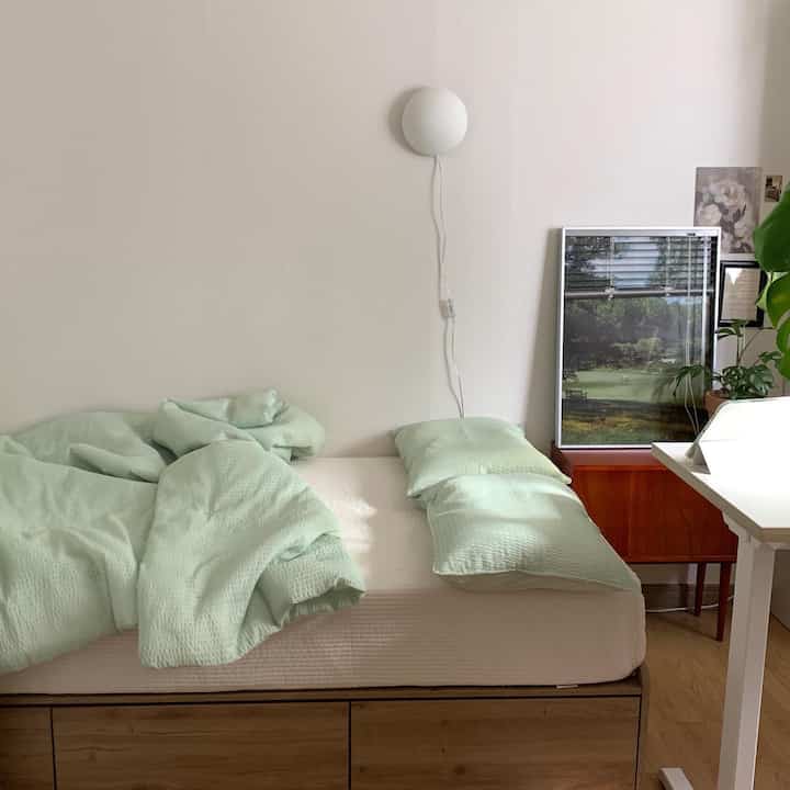 Natural modern 6-tatami bedroom featuring wood tone bed and soft green bedding creating a cozy atmosphere