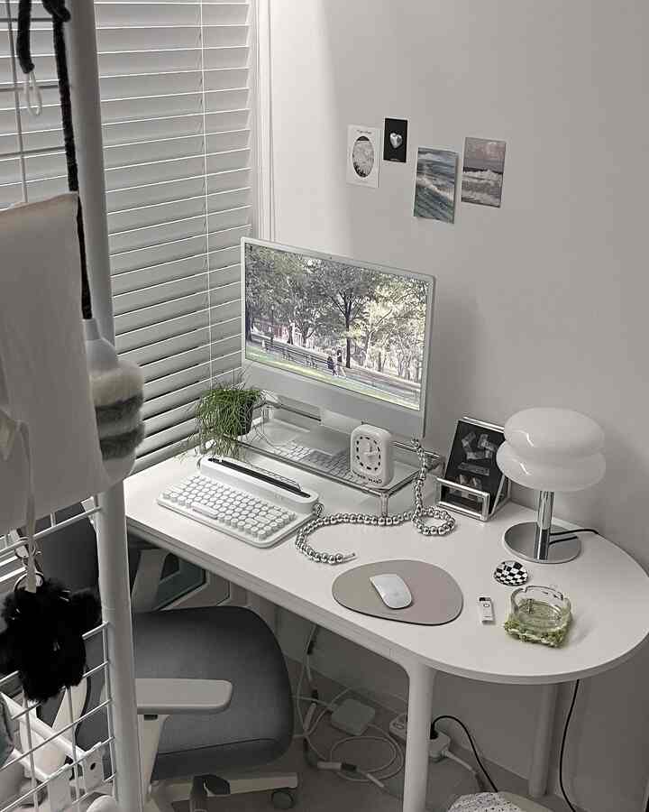 White and gray toned home office space featuring a clean desk with computer monitor, creating a neat workspace atmosphere