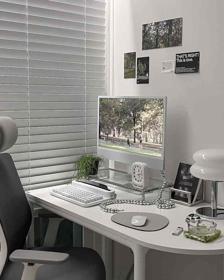 白を基調としたホームオフィス、シンプルなデスクとモニター、オフィスチェアが配置されたミニマルなワークスペース