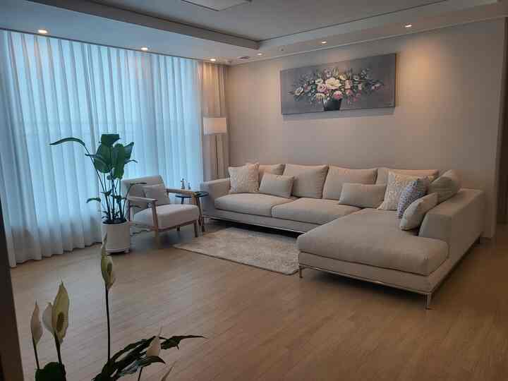 Beige-toned living room featuring a large 3-seater sofa and armchair in a simple, natural modern space