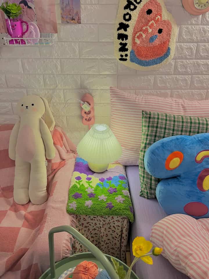 Bedroom with pink and vintage patterns featuring soft cushions and a cozy rug creating a warm atmosphere