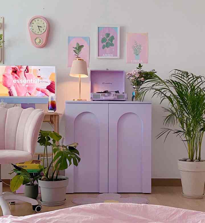 Pastel-toned living room featuring vintage decor, plants, and stylish cozy interior elements