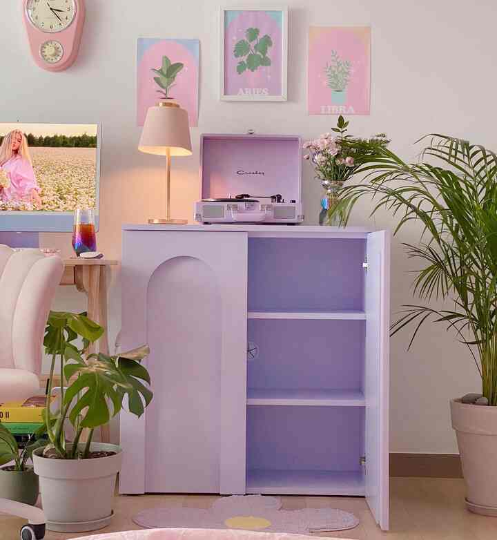 柔らかなラベンダーとホワイトの色調のリビング、レトロなLPプレーヤーと植物が配置された雰囲気のあるインテリア