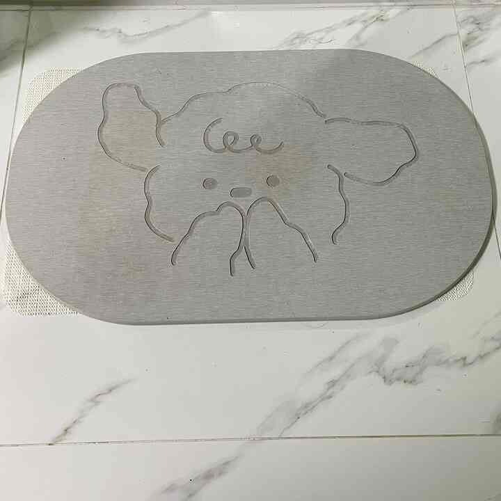 グレー調の浴室床に犬の形がカットされた珪藻土製のバスマットが置かれた空間