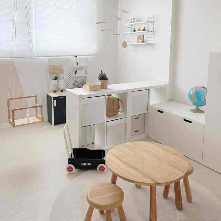 ホワイトと木目調が調和した子供部屋、木製家具とモビールがアクセントの素朴な空間