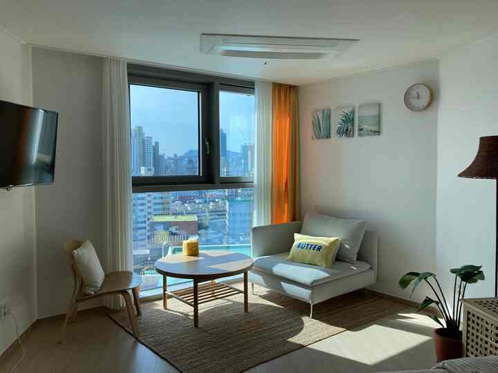 White and brown toned two-person living room featuring a round table and natural furniture with cozy atmosphere