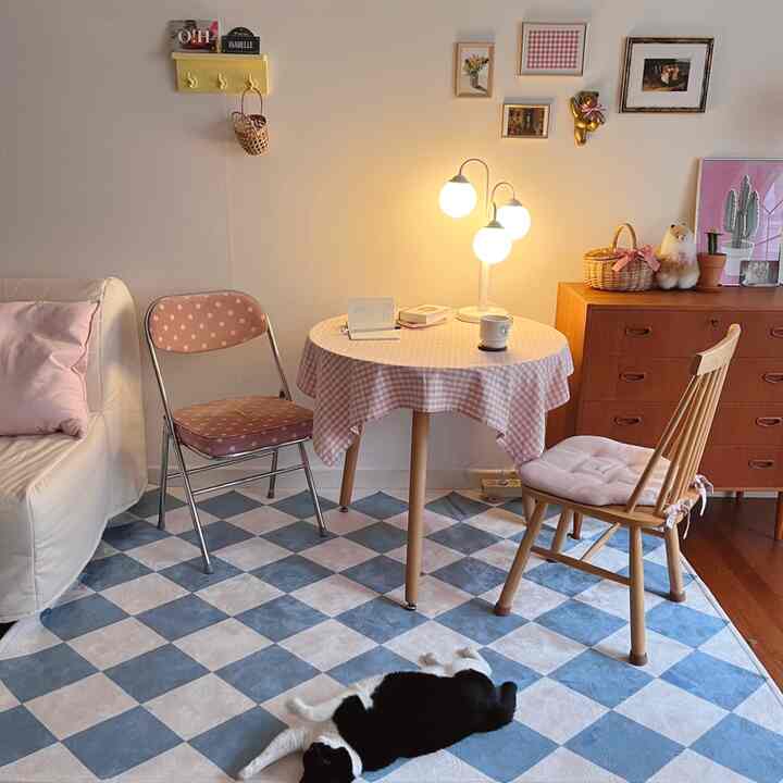 Living room in pink and wood tones featuring a checkerboard rug and cozy lighting creating a warm atmosphere