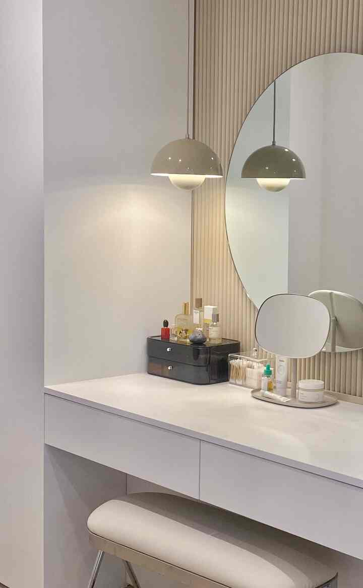 White-toned powder room featuring a round mirror and pendant light in a simple and clean space