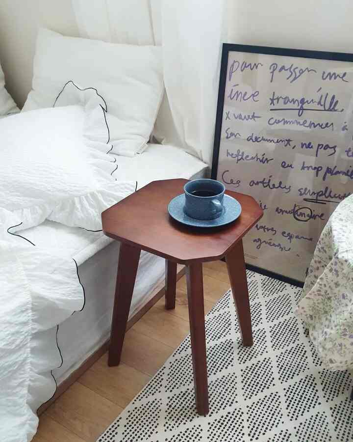 A calm 6-tatami bedroom in white and wood tones featuring a small stool with a blue coffee cup on top
