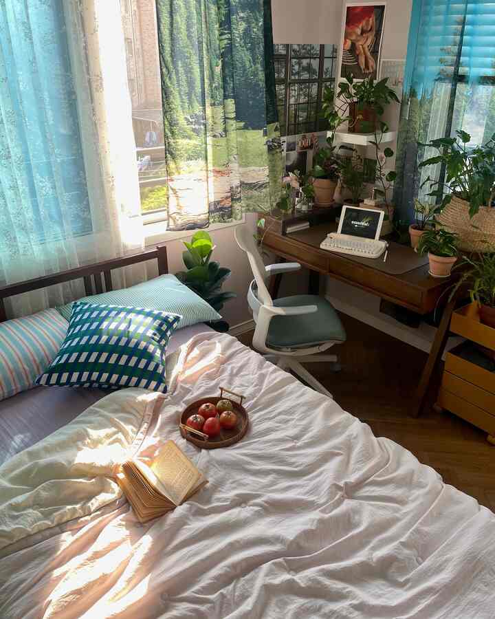 White and green toned bedroom featuring desk, office chair, and plants in a cozy home office setup