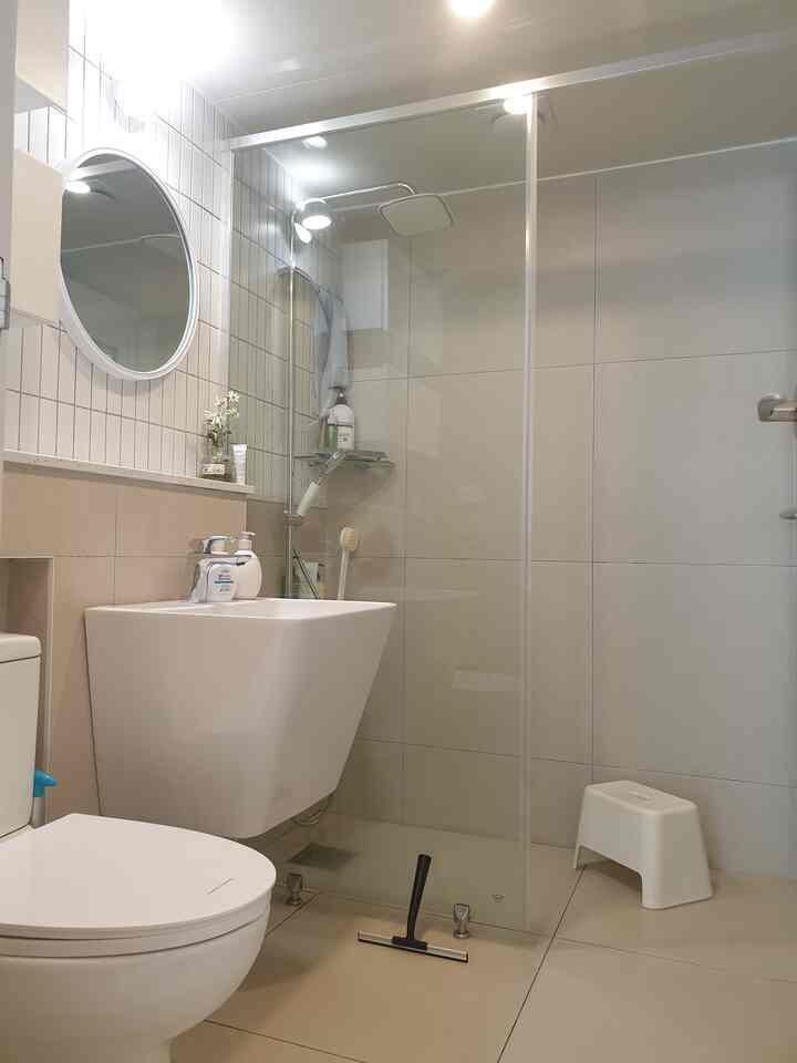 White and beige toned bathroom featuring modern sink and shower, clean and serene space