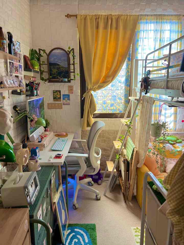 黄色いカーテンと白いデスク、二段ベッドが配置されたコンパクトで居心地の良いホームオフィス空間