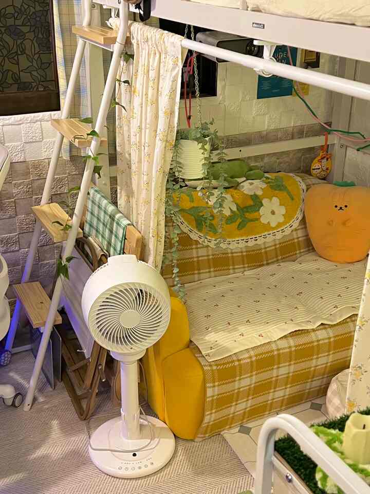 白と黄色のトーンの狭いリビング、二段ベッドと黄色のソファにブランケットとクッションが配置された雰囲気のあるインテリア