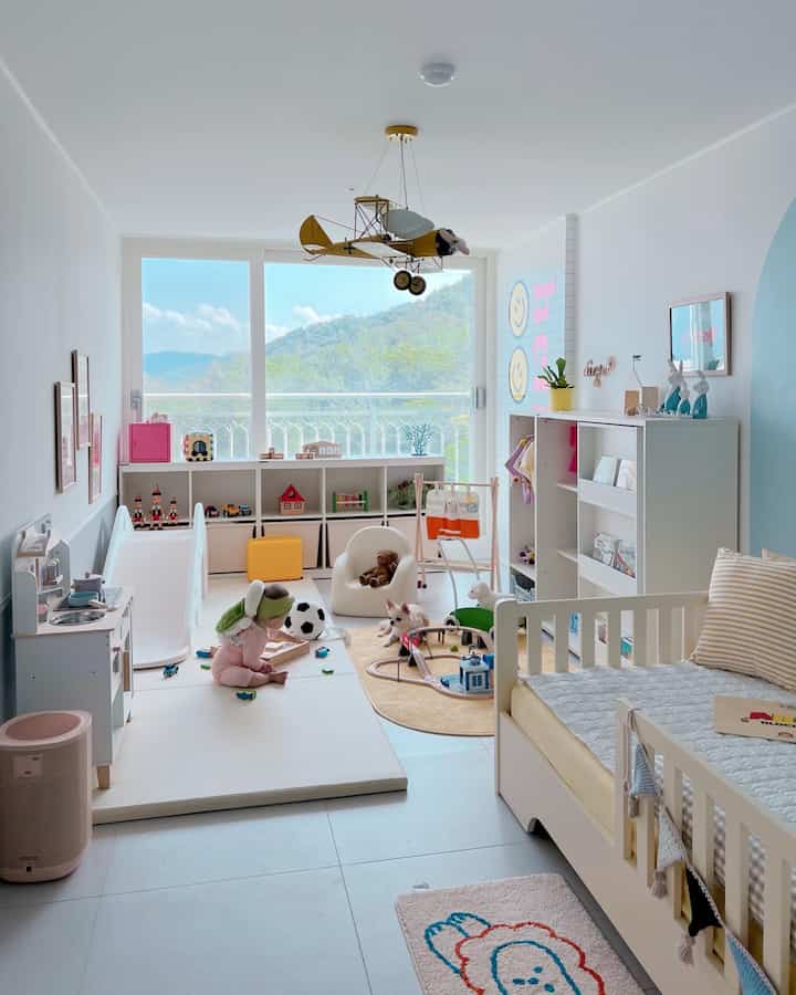 Bright and cozy kids' room in white and natural tones featuring a children's bed and play area with toys
