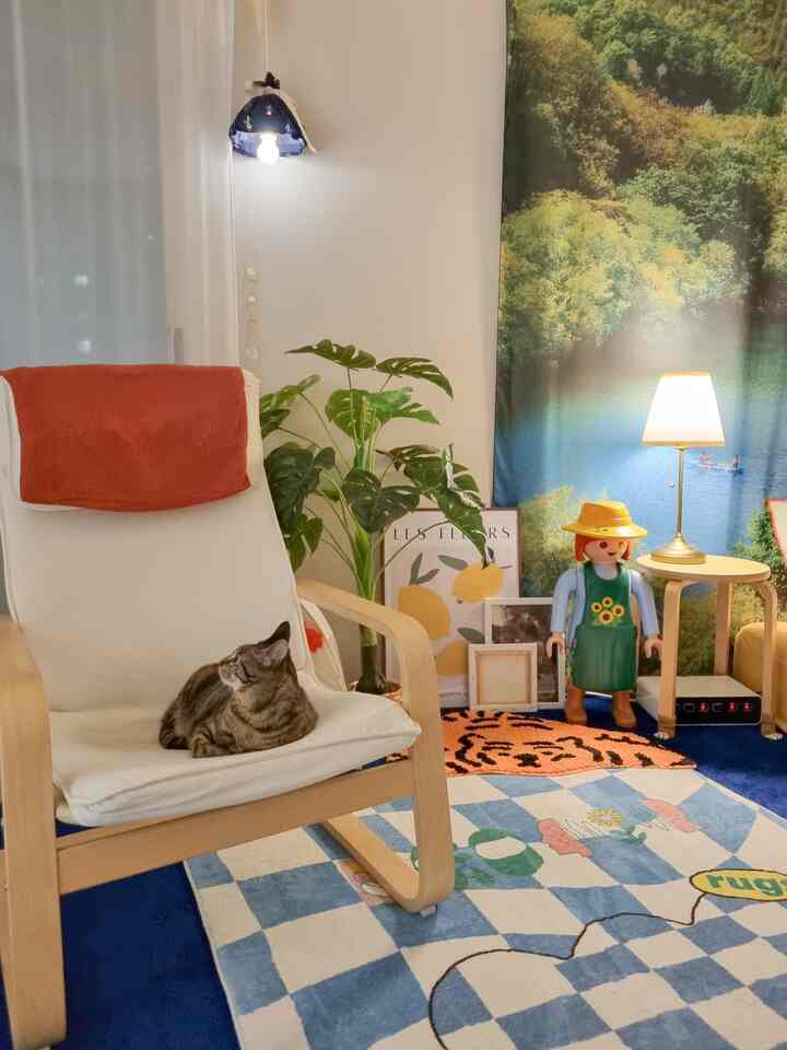 Natural color and blue tones blend in a bedroom featuring an armchair with a cat resting on it, creating a cozy atmosphere