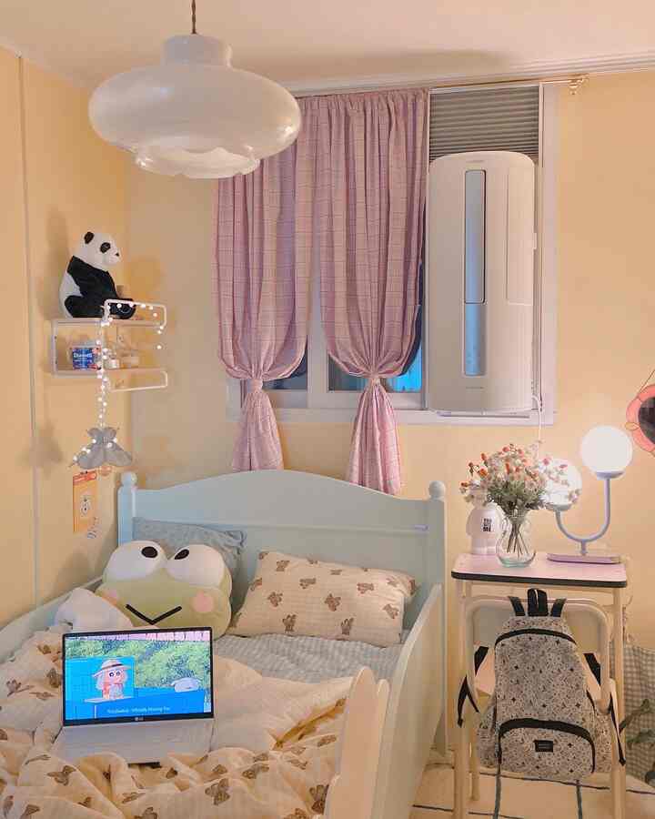 Pastel-toned kids' room featuring pink check curtains and cute character cushions creating a cozy atmosphere