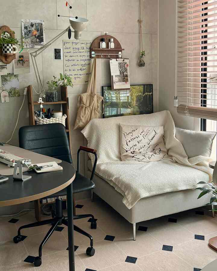 Natural tone living room with wood blinds and white sofa featuring a home office setup for a single household